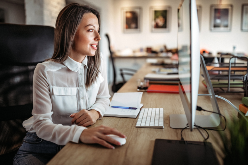 business woman sits at her computer writing  policy and procedure documents
